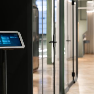 Donkere Framery One Compact naast werkplekken in een open kantoor