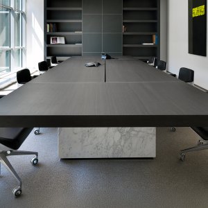 Twee ongelijke voeten onder de vergadertafel Asymmetrical Meeting